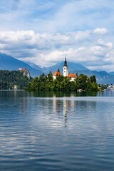 Panoramic view from Lake Bled, beauty heritage in Slovenia. Island with church and castle in the background create a dream setting. View from Ojstrica and Mala Osojnica with the heart-shaped bench.