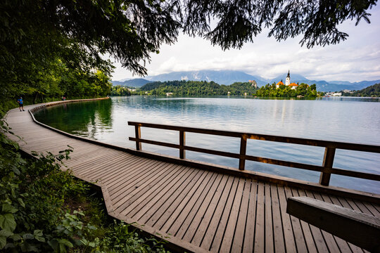 Panoramic view from Lake Bled, beauty heritage in Slovenia. Island with church and castle in the background create a dream setting. View from Ojstrica and Mala Osojnica with the heart-shaped bench.