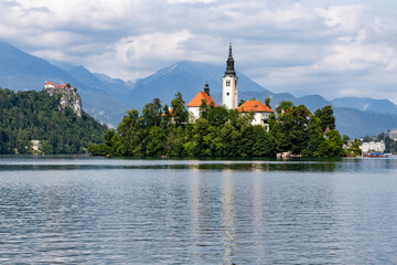 Panoramic view from Lake Bled, beauty heritage in Slovenia. Island with church and castle in the background create a dream setting. View from Ojstrica and Mala Osojnica with the heart-shaped bench.
