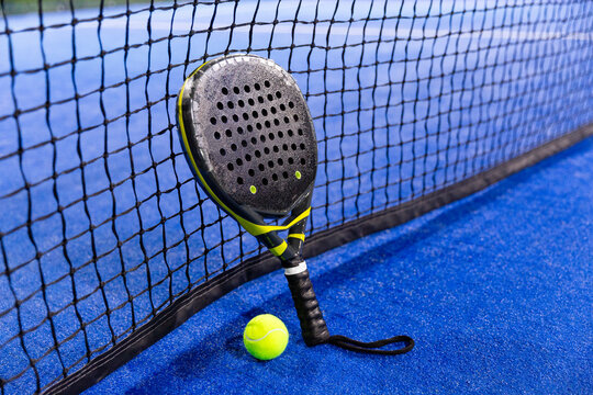 padel racket on a padel blue court with a ball 