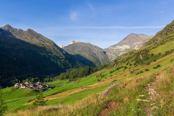 Naklejka premium Rural scene with mountain panorama of summits Hohe Weisse and Hochwilde and houses in village Pfelders near Texel group, South Tyrol, Italy