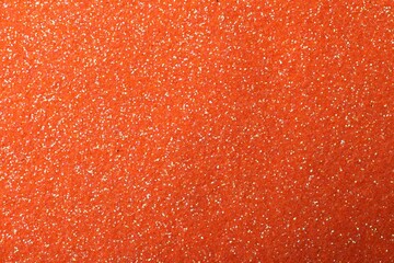 Beautiful shiny orange glitter as background, closeup