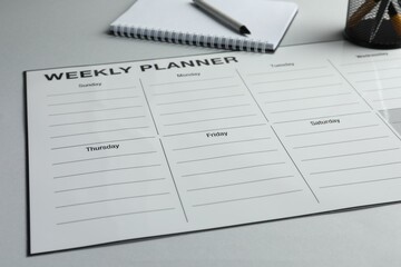 Timetable. Planner, notebook and pen on grey table, closeup