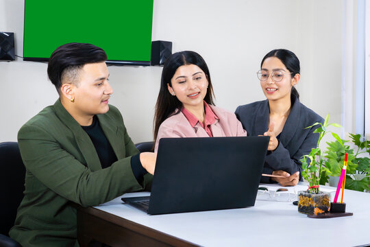 an office team of business man and woman in front of a green screen in a meeting table discussing