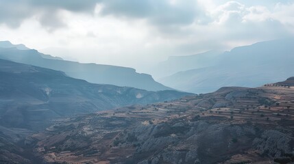 Obraz premium Majestic Mountainous Terrain Under Cloudy Skies