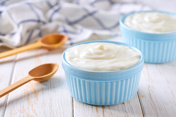 homemade organic yogurt in a ceramic bowl with spoon on a light background, selective focus.