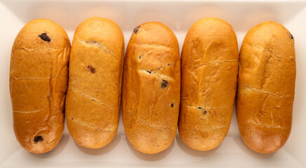 Several sweet buns on a ceramic dish, macro, top view.