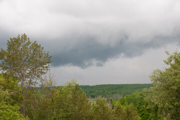 A gray cloud over a hilly forest in the spring