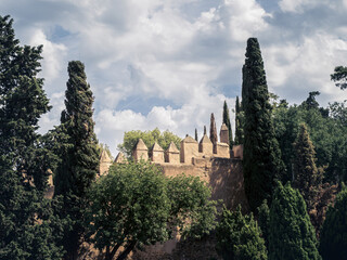 Walls and bastion of the castle fort Gibralfaro with trees of the gardens, Malaga