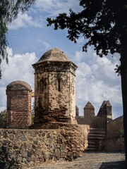 Walls and bastion of the castle fort Gibralfaro with trees of the gardens, Malaga