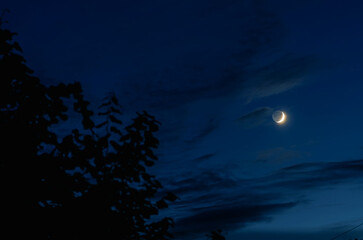 Growing moon on background of the blue sky at night. Astrophoto