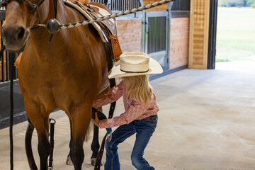 Little girl cowgirl with bay horse