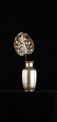 golden palm leaves in a golden vase on a black background