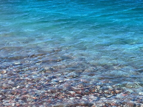 Sea blue waves on pebbly beach