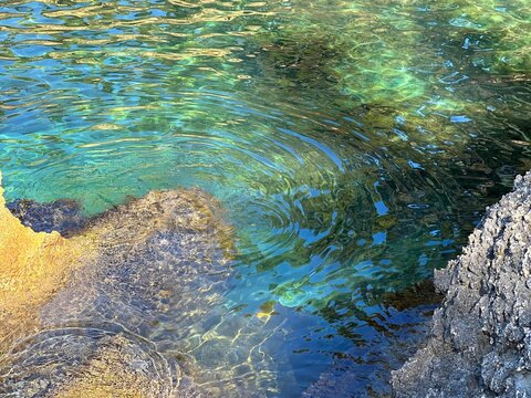 Ripples on the sea water by rocky coast.