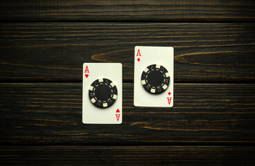 Lucky omen of two aces or one pair on an antique table in a club. Playing cards and chips on an antique black table