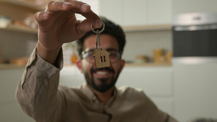 Smiling Arabian man happy Indian guy real estate renter homeowner owner of apartment hold bunch of...