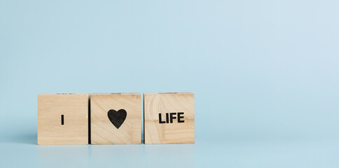 Wooden cubes with inscriptions I Love Life on a blue background
