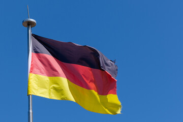 View of the national flag of Germany against a blue sky