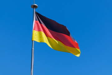 View of the national flag of Germany against a blue sky