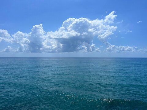 Blue sea water and beatiful clouds in the sunny sky.