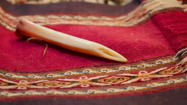 Alpaca Bone Tool Used by Quechua Artisans on Alpaca and Llama Wool Fabric. Andean Weaving Tool on Traditional Fabric