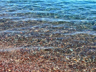 Transparent sea water on pebble beach. 