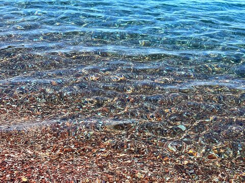 Transparent sea water on pebble beach. 
