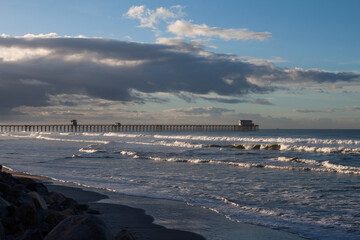 Waves breaking with a pier in the background