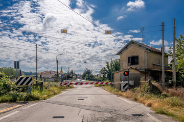 Closed level crossing with red light near old abandoned railroad crossing house on the railway line...