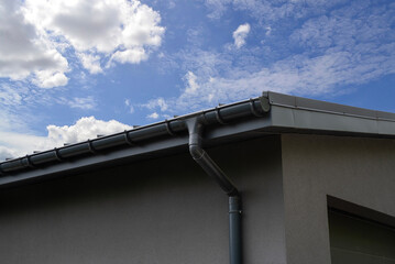 Plastic gutter system on a house against a blue sky