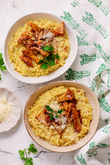 Orzotto with chanterelles, Parmesan cheese and parsley in a deep ceramic bowl.