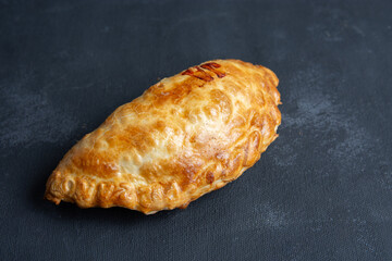 empanada argentina recien horneada en fondo negro