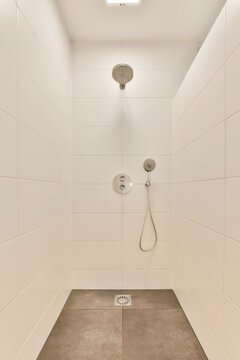 A bathroom with white tiled walls and a shower