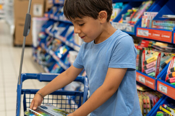 Young boy shopping for school supplies in a store