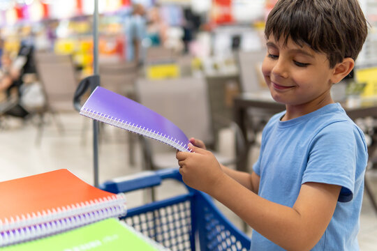 Young boy shopping for colorful school notebooks - Powered by Adobe