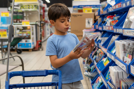 Young boy choosing school supplies in a store aisle