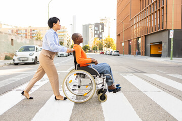 Supportive businesswoman assisting colleague in wheelchair