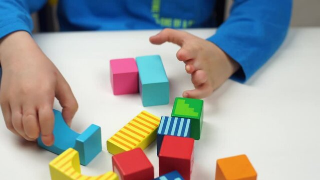 Close up of hands with amniotic band syndrome building colorful wooden blocks
