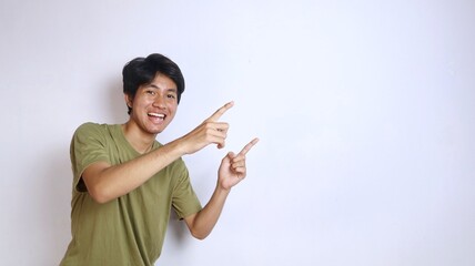 excited young asian man pointing to the side on isolated white background