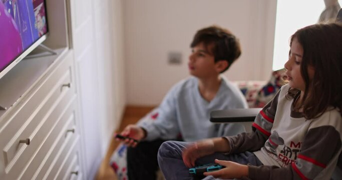 Boys intensely focused on his video game console. They are engrossed in the virtual world, oblivious to the surroundings.
