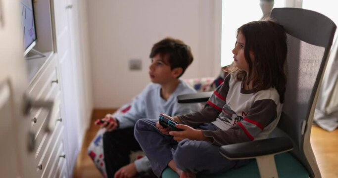 Boys intensely focused on his video game console. They are engrossed in the virtual world, oblivious to the surroundings.
