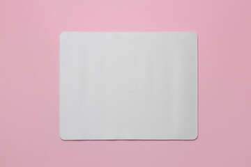 One mouse pad on pink background, top view. Space for text