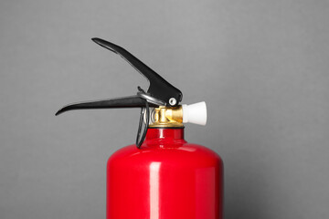 One red fire extinguisher on gray background