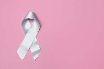 International Psoriasis Day. Light blue ribbon as symbol of support on pink background, top view. Space for text