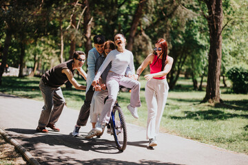 A joyful moment as three friends share fun on a bicycle ride through a sunny, green park over the weekend