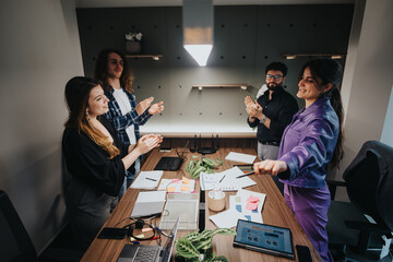 A diverse group of young professionals engaging enthusiastically in a collaborative business meeting in a stylish office setting.