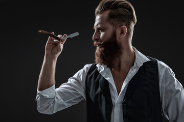 Hairstylist serving at barber shop. Barbershop. Man with red beard. Hairstylist at barber shop isolated on black. Barber using retro blade. Brutal hairdresser cutting hair. Classic razor