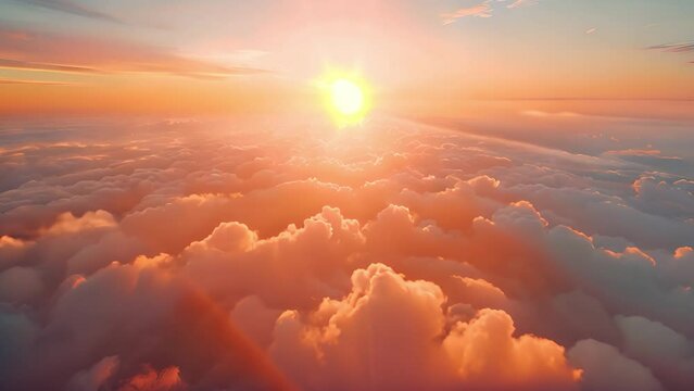 A stunning sunset over clouds from a high altitude vantage point. The sun is setting in the distance, casting warm light across the sky and clouds.