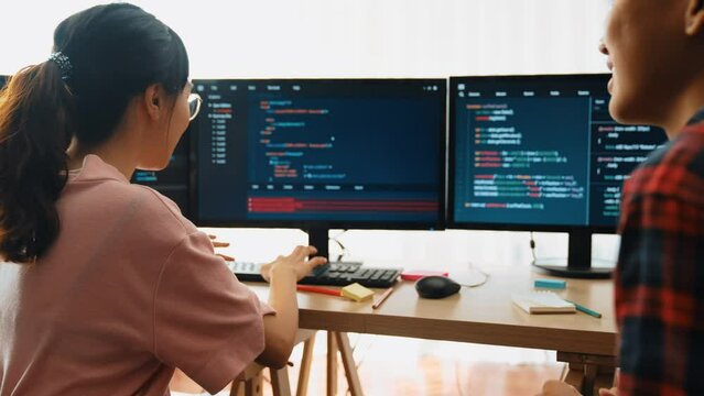 Slow motion back end software developer engineer for computer programming working together on debugging writing computing code, solving complex algorithms display on monitor in office. Burgeoning